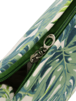 Tropische koffers met groen gebladerte en close-up ritsdetails Tropische koffers met groen gebladerte en close-up ritsdetails