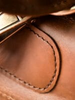 Faltbare Kulturtasche aus braunem Leder mit Lederdetails und Nähten Faltbare Kulturtasche aus braunem Leder mit Lederdetails und Nähten