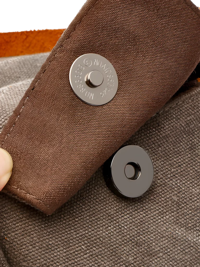 Neceser de hombre de lona e inserciones de piel con detalles de botones magnéticos